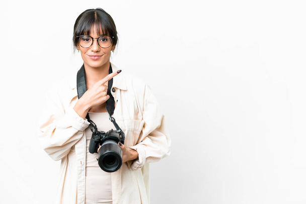 Молодой фотограф кавказская женщина на изолированном белом фоне указывая в сторону, чтобы представить продукт - Фото, изображение