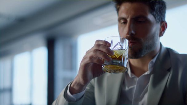 Leader person drinking whiskey in restaurant closeup. Handsome gentleman portrait tasting beverage with unknown colleague in luxury panoramic window cafe. Businesspeople hands holding bourbon glasses - Foto, imagen