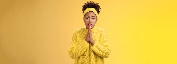 Intense worried perplexed young gloomy african-american woman hold hands pray frowning cringing begging favour standing troubled bad situation need help forgiveness feel awkward, yellow background. - Photo, Image