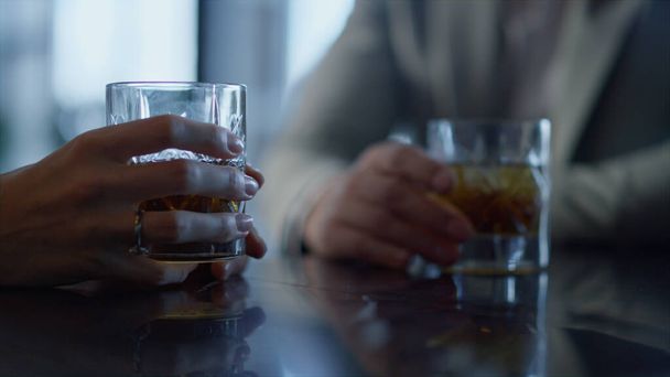 Collega 's die whisky cocktails drinken in restaurant close-up. Onbekende zakenpartners bespreken met alcohol bourbon dranken op bedrijfsevenement in chique plaats. Rijke ondernemers op vergadering. - Foto, afbeelding
