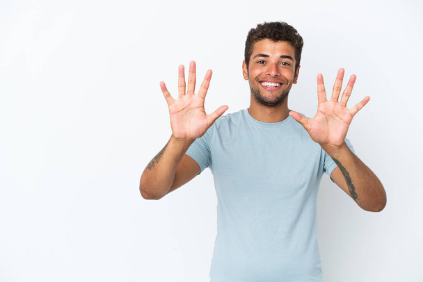Молодий вродливий бразильський чоловік, що живе на білому фоні, рахує десять пальцями. - Фото, зображення
