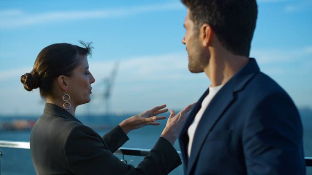 Successful people discussing business plans closeup. Two workers resting break enjoying sea port view on balcony. Sales professional businesswoman talking handsome businessman in sunlight outdoors. - 写真・画像