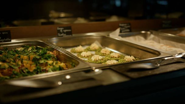 Catering buffet food setting in modern restaurant closeup. Tasty organic vegan dishes displaying in luxury hotel cafe. Delicious meal trays serving at corporate lunch party. Self-service concept. - Foto, Imagen
