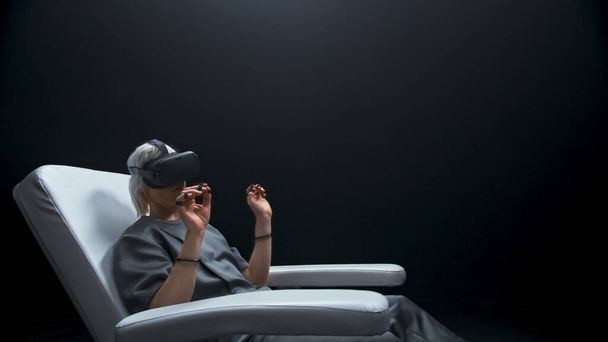 Przyszły programista uczy VR niewidzialny ekran zbliżenie. Kontrolerzy czujników testują rozszerzoną platformę rzeczywistości siedzącą na fotelu. Inteligentny specjalista przesuwający obrazy cyberprzestrzeni w okularach cyfrowych - Zdjęcie, obraz