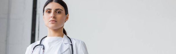 γυναίκα γιατρός με λευκό παλτό κοιτάζοντας κάμερα στο νοσοκομείο, πανό  - Φωτογραφία, εικόνα