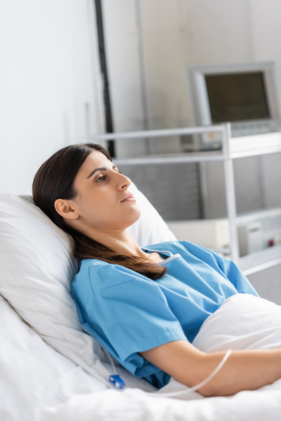 Paziente malato in abito sdraiato vicino alla terapia endovenosa in clinica  - Foto, immagini