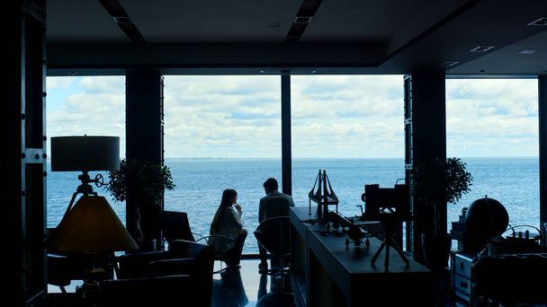 Partners silhouettes working panorama window. Unknown focused colleagues sitting at luxury secretary leaving room. Businesswoman and client investor analyzing at sea view. Corporate lifestyle concept  - Foto, immagini