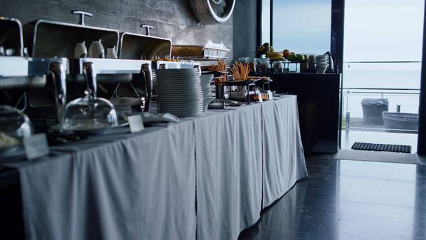 Catering buffet food table serving for business event lunch in stylish cafe bar. Luxury tablewear and delicious snacks setting in cozy hotel restaurant. Heated meal trays standing in modern cafeteria. - Foto, imagen