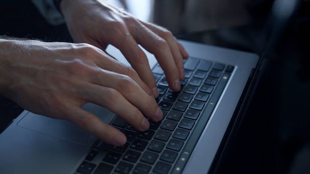 Closeup director hands work touchpad laptop at dark office interior. Busy unknown man employee typing notebook keyboard in office. Unrecognizable businessman pushing buttons at hotel lobby workplace  - Photo, Image