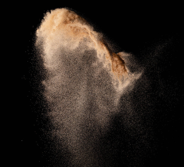 Small size fine Sand flying explosion, Golden grain wave explode. Abstract cloud fly. Yellow colored sand splash silica in Air. Element Black background Isolated high speed throwing freeze shot - Photo, Image