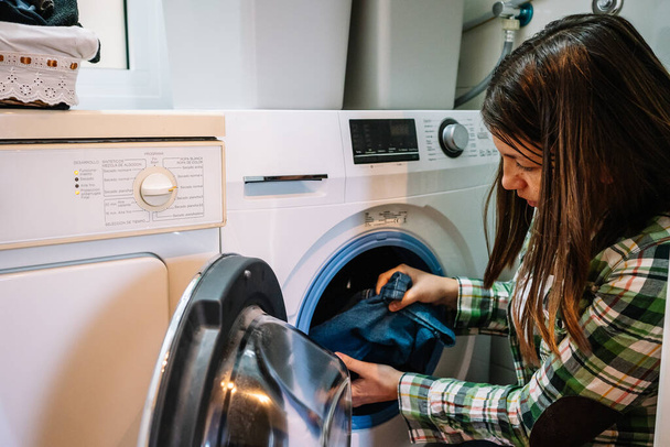 femme met machine à laver à la maison. Photo de haute qualité - Photo, image