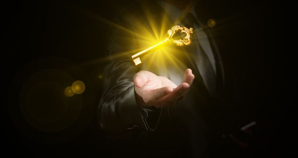 Geschäftsmann hält goldglänzenden Schlüssel, Geschäftskonzept - Foto, Bild