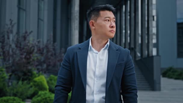Besorgt schaut sich ein trauriger Mann mittleren Alters in der Stadt um. Asiatischer koreanischer Geschäftsmann in den 40er Jahren schaut auf Armbanduhr wartendes Taxi trifft Geschäftspartner besorgt über Verspätung - Filmmaterial, Video