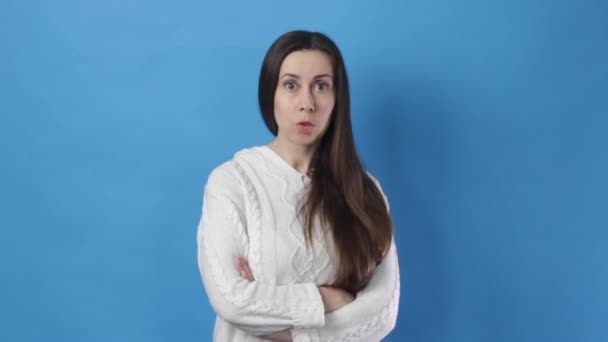 the girl thoughtfully clarifies the question does not understand what they want from her on a blue background - Footage, Video
