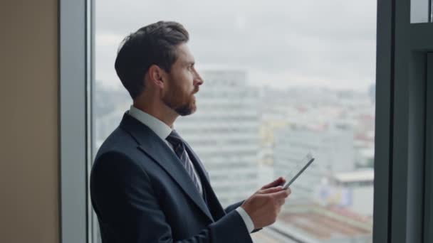 Successful confident boss holding tablet rejoicing company achievement reading financial report close up. Attractive bearded business man feeling happy standing with tab computer near office window. - Footage, Video