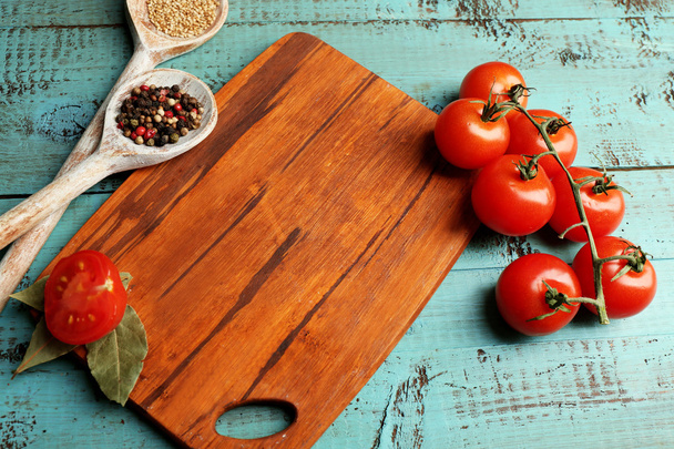 Different spices and herbs with cutting board on color wooden table background - Foto, Imagem
