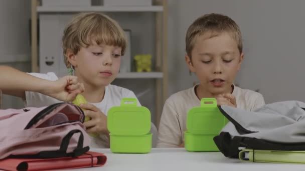 Menino e menina estão comendo seus lanches na mesa. Imagens 4k de alta qualidade - Filmagem, Vídeo