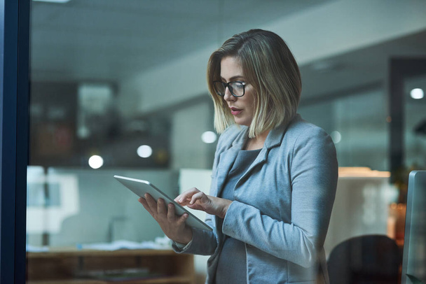 Travailler plus intelligemment, pas plus dur. une femme d'affaires travaillant sur une tablette numérique dans son bureau tard dans la nuit - Photo, image