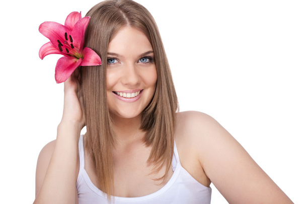 Smiling woman with pink lily - Zdjęcie, obraz