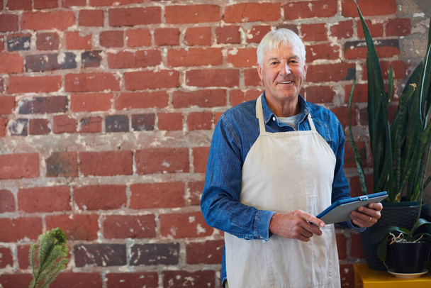 Che ha parlato di andare in pensione. Ritratto di un imprenditore anziano fiducioso in posa con un grembiule nella sua caffetteria - Foto, immagini