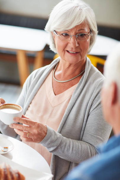 Koffie en conversatie gaan zo goed samen. een gelukkig senior koppel ontspannen met een kopje koffie in een coffeeshop - Foto, afbeelding