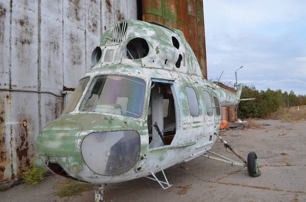 Listo para la reparación helicóptero en un estado semi-desmantelado está esperando en las alas - Foto, Imagen