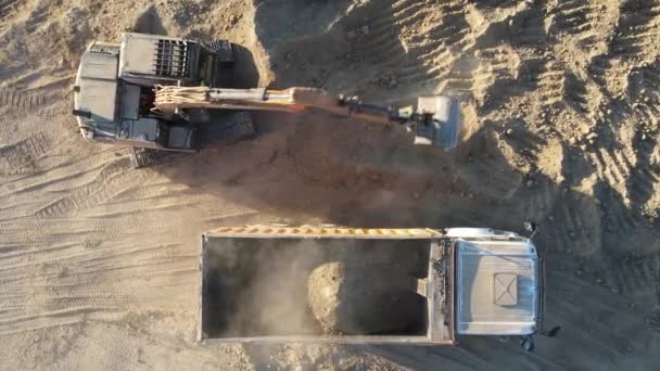 Αεροφωτογραφία του εκσκαφέα που μεταφέρει άμμο από έδαφος σε φορτηγό, του εκσκαφέα που φορτώνει φορτηγά, του εκσκαφέα που φορτώνει άμμο σε σκουπιδιάρικο - Πλάνα, βίντεο