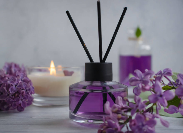 Perfume for home, lilac flower, candle on a light background - Photo, Image