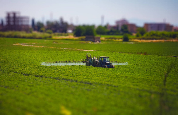 Yeşil alana böcek ilacı püskürten traktör.. - Fotoğraf, Görsel
