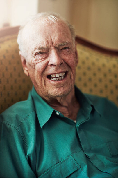 Im just a young man with wrinkles. Cropped portrait of a happy senior man sitting by himself in a living room - Photo, Image
