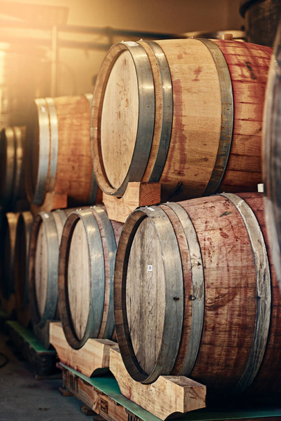 De los que saben mejor. barriles de vino apilados entre sí en una destilería de vino - Foto, imagen
