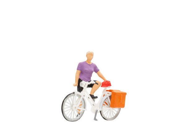 Миниатюрные люди, велосипедист с седлом мешок изолирован на белом фоне с вырезкой пути - Фото, изображение