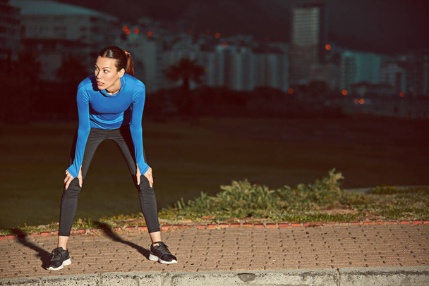 A forgalmas utcák nem forgalmasak hajnali 4-kor. Egy sportos fiatal nő szünetet tart a futás után. - Fotó, kép