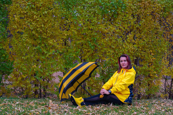 guarda-chuva preto amarelo e menina em amarelo. Foto de alta qualidade - Foto, Imagem