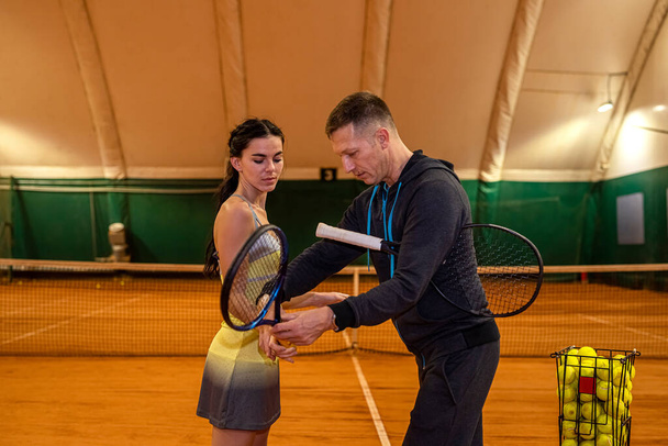 par de tenistas un hombre y una mujer están de pie en una cancha de tenis con raquetas. concepto deportivo. Deportes de pareja - Foto, Imagen