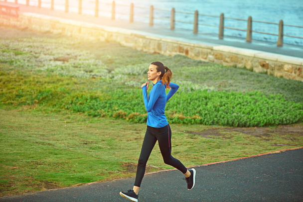 A futás a meditációm. egy sportos fiatal nő, aki futni ment - Fotó, kép