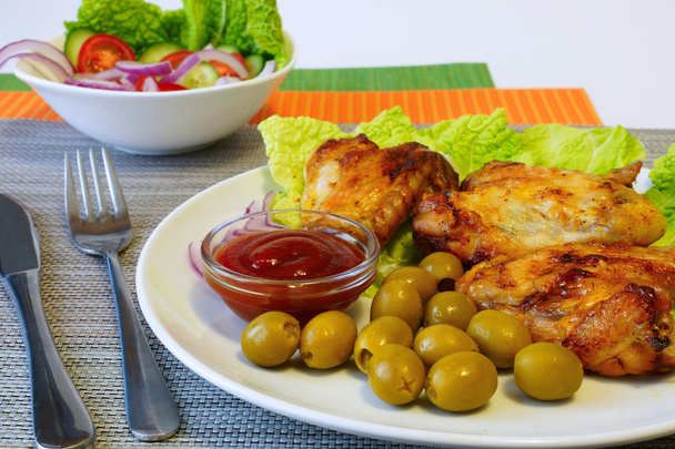 Alitas de pollo, aceitunas verdes y ensalada de verduras
 - Foto, Imagen
