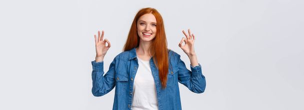 Waist-up portrait modern good-looking redhead girl in casual shirt, showing okay gestures and smiling, nod in approval, agreement, rate good movie, perfect service, stand white background. - Photo, Image