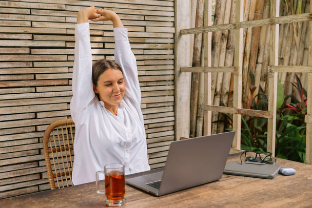 Junge glückliche positive Geschäftsfrau sitzt drinnen in Co-Arbeit mit Laptop-Computer. - Foto, Bild