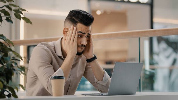 Smutny zszokowany etniczny CEO Indian man worker manager freelancer przedsiębiorca menedżer w kawiarni ma problem z laptopem aplikacji czytanie złych wiadomości martwi się porażką e-mail szok biznes stracił pracę - Zdjęcie, obraz