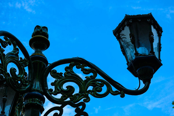 Типичная уличная лампа в Малиоборо с голубым небом и белым облаком. Зеленый фонарь в стиле ретро на улице Малиоборо. Винтажная лампа на историческом городе Джокьякарта. - Фото, изображение