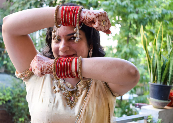 Όμορφη γυναίκα ντυμένος ως ινδική παράδοση με henna mehndi σχεδιασμό και στα δύο χέρια της για να γιορτάσει μεγάλο φεστιβάλ της Karwa Chauth, Karwa Chauth γιορτές από Ινδή γυναίκα για τον σύζυγό της - Φωτογραφία, εικόνα