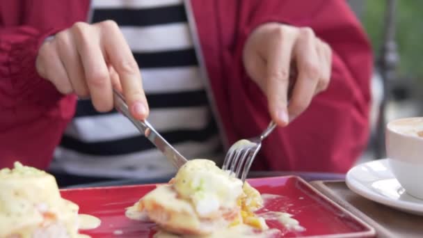 Großaufnahme eines Tellers: Eine Frau frühstückt in der Türkei mit pochierten Eiern. - Filmmaterial, Video