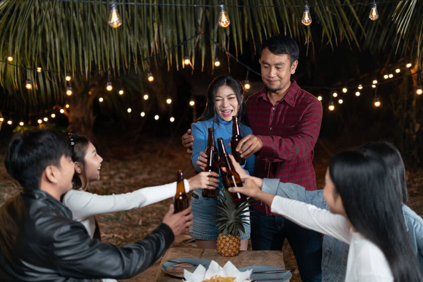 Young couples and friends enjoy a happy holiday party drinking beer together. - Photo, Image