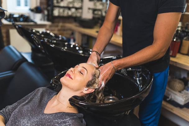 Coiffeur appliquer le shampooing et masser les cheveux et la tête des clients. Concept de salon esthéticienne. Des clients heureux. Photo de haute qualité - Photo, image