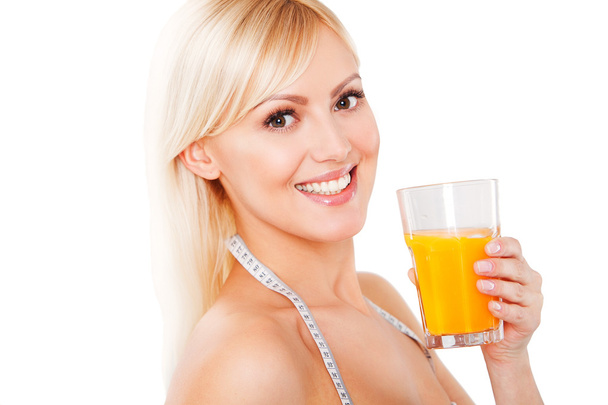 blond woman with the measuring tape drinking orange juice - Фото, изображение