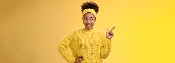 Charming tender young easy-going millennial stylish girl in sweater hold hand waist confident pointing looking impressed upper left corner smiling broadly ineterested, curiously discussing product. - Photo, Image