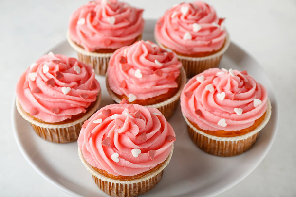 Stand con gustosi cupcake per San Valentino su sfondo bianco, primo piano - Foto, immagini