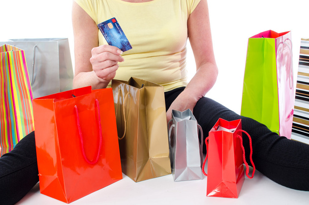 Sacs à provisions autour d'une femme tenant une carte de crédit
 - Photo, image