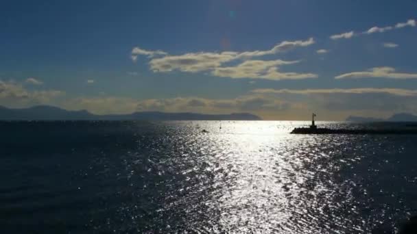 Sparkling water surface ,horizon,skyline, silhouettes breakwater and motor boat - Footage, Video